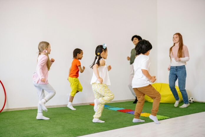 Group of children engaged in fun activities indoors with teachers.